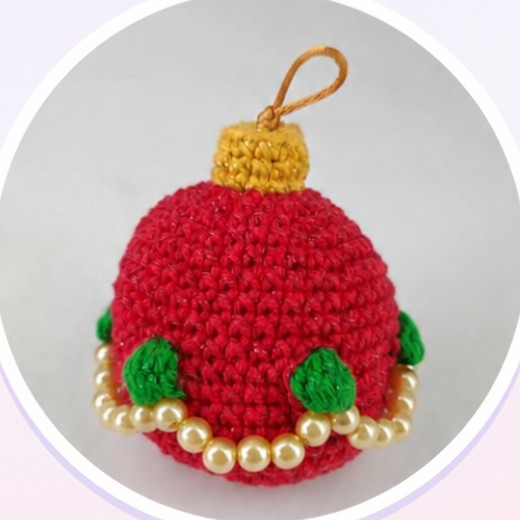 Franchie, bolinha de Natal de amigurumi vermelha com cordão de pérolas